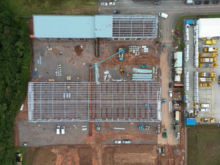 Aerial view of the construction site at West Park, Wellington, showcasing the dynamic scene with contractors actively working on the development, including the installation of roofing cladding.