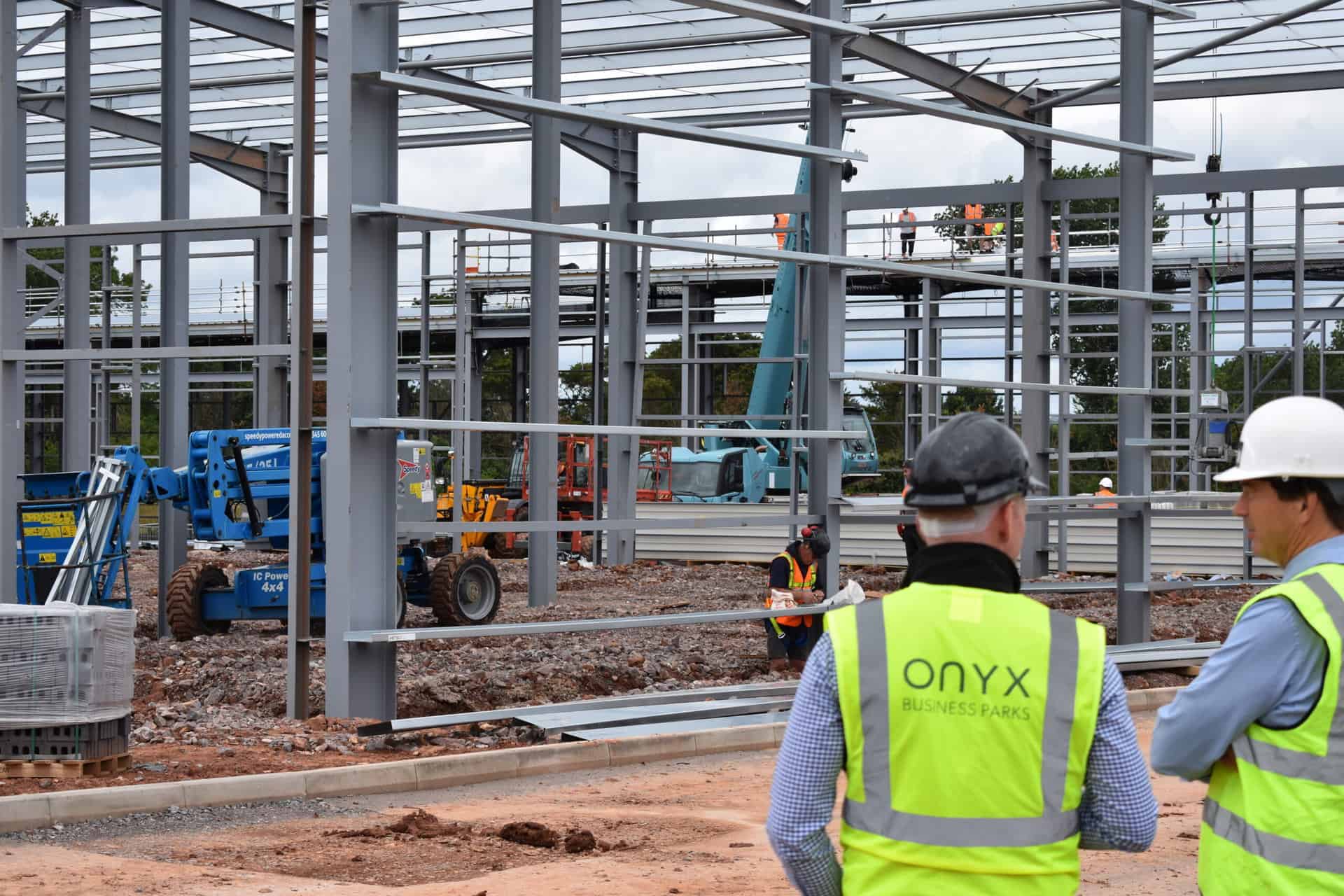 Onyx team member at the West Park, Wellington construction site, wearing a high-visibility vest featuring 'Onyx.' The site showcases progress with steel beams in place, signalling the advancement of the development phase.