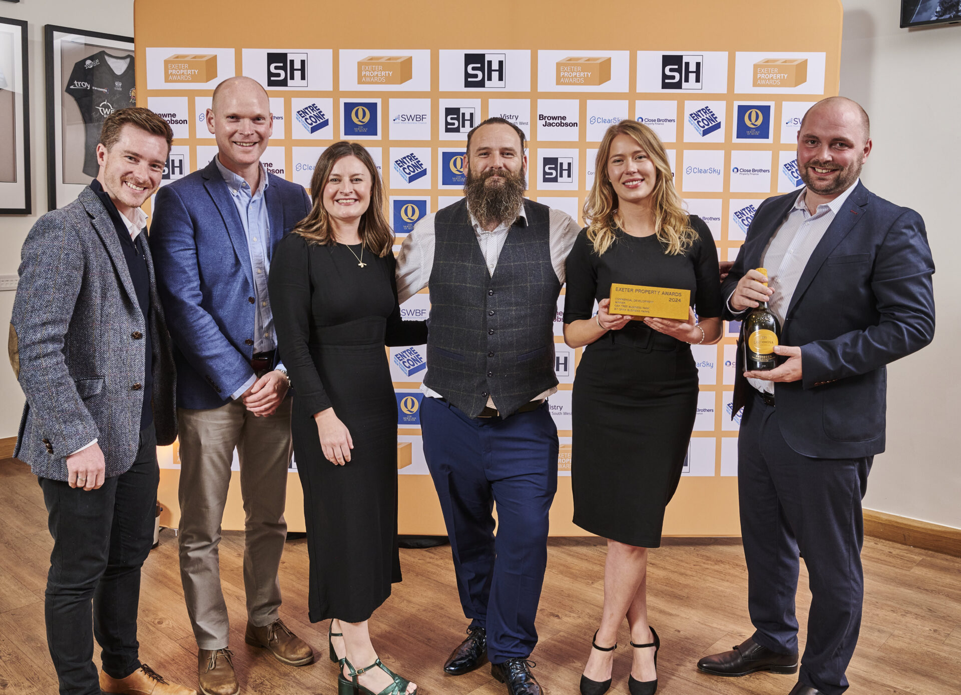 6 people standing together holding a prize