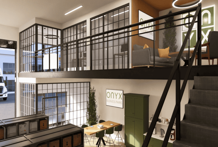 A modern industrial unit showcasing a mezzanine office space with a storage area below. The upper level features glass partitions, a seating area with grey sofas, and a round meeting table with green chairs. The lower level includes a green cabinet, a small kitchen area, and a long table with green chairs. The ONYX Business Parks logo is displayed on the wall.