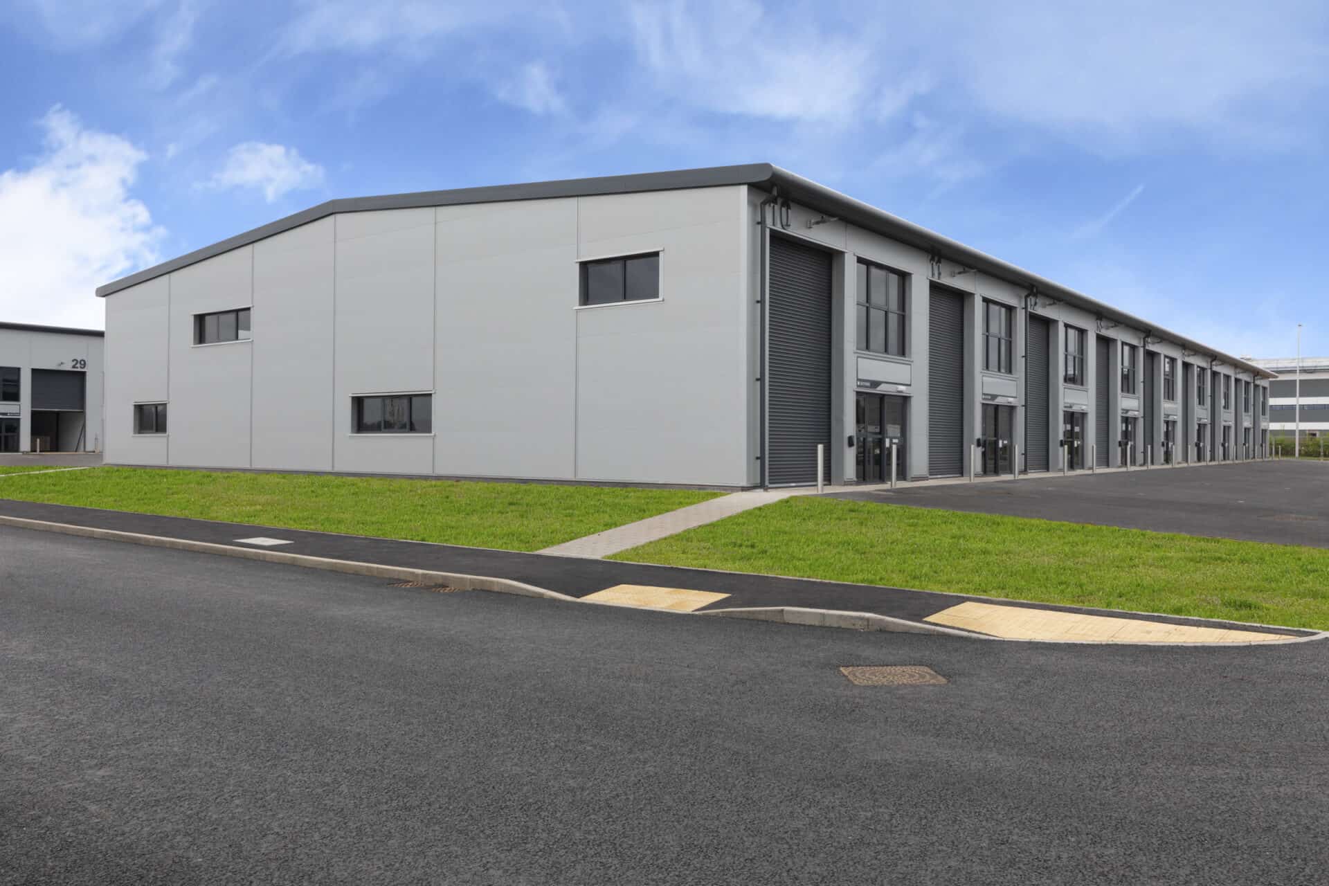 Sunny day view of the completed light industrial units at Skypark. This picturesque scene showcases the successful development of versatile workspaces in a beautiful setting