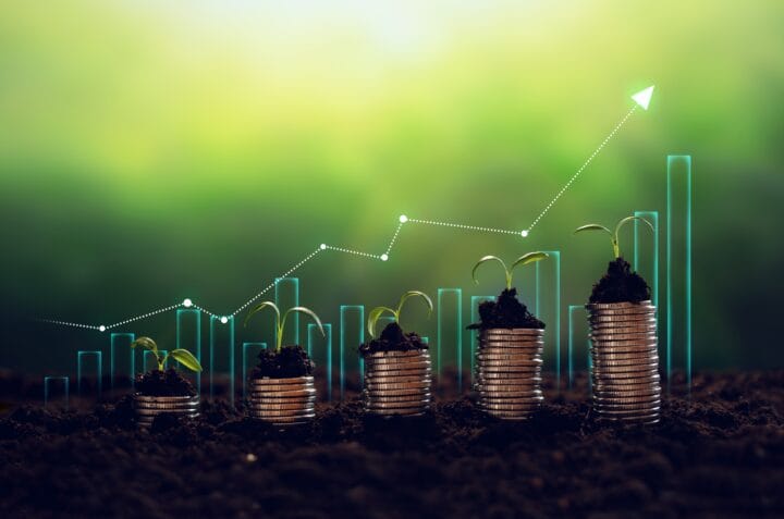 stacks of coins increasing in size from left to right, with plants growing out the top of them, highlighting the possibility for increasing ROI from sustainable commercial property investments.